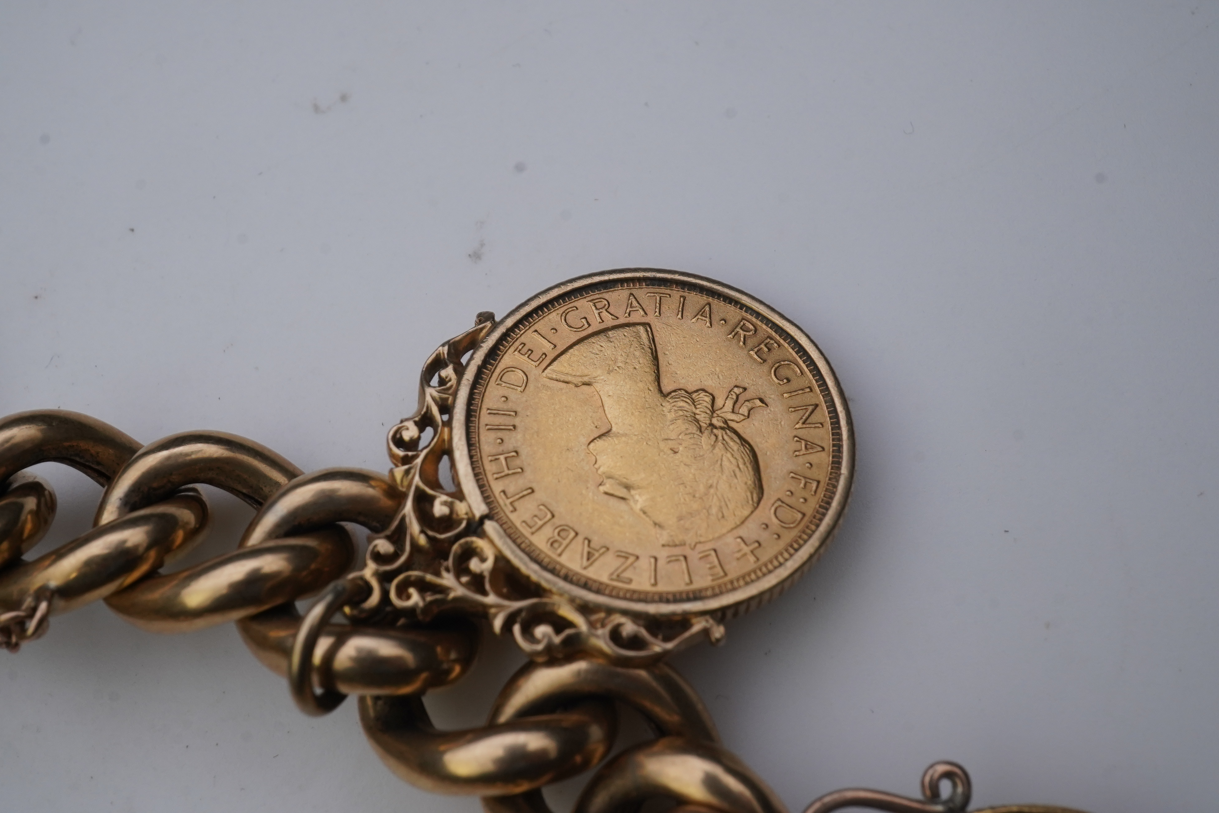 An Edwardian 18ct gold charm bracelet and five gold coin pendants